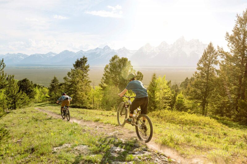two people mountain biking on trail