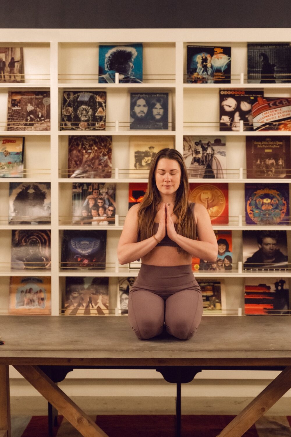 A woman practicing yoga. Records in the background.