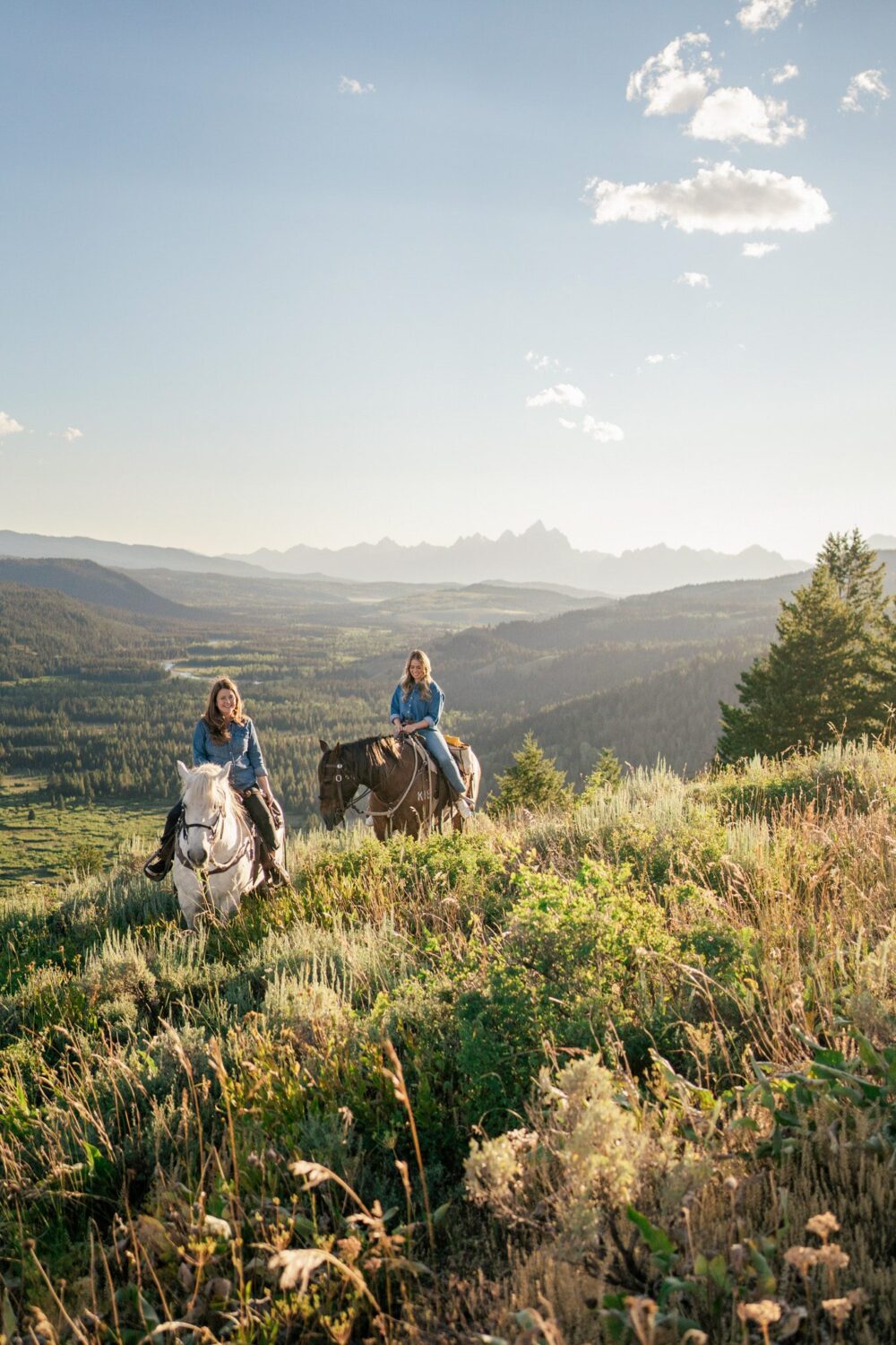 Two women horseback riding in Wyoming.